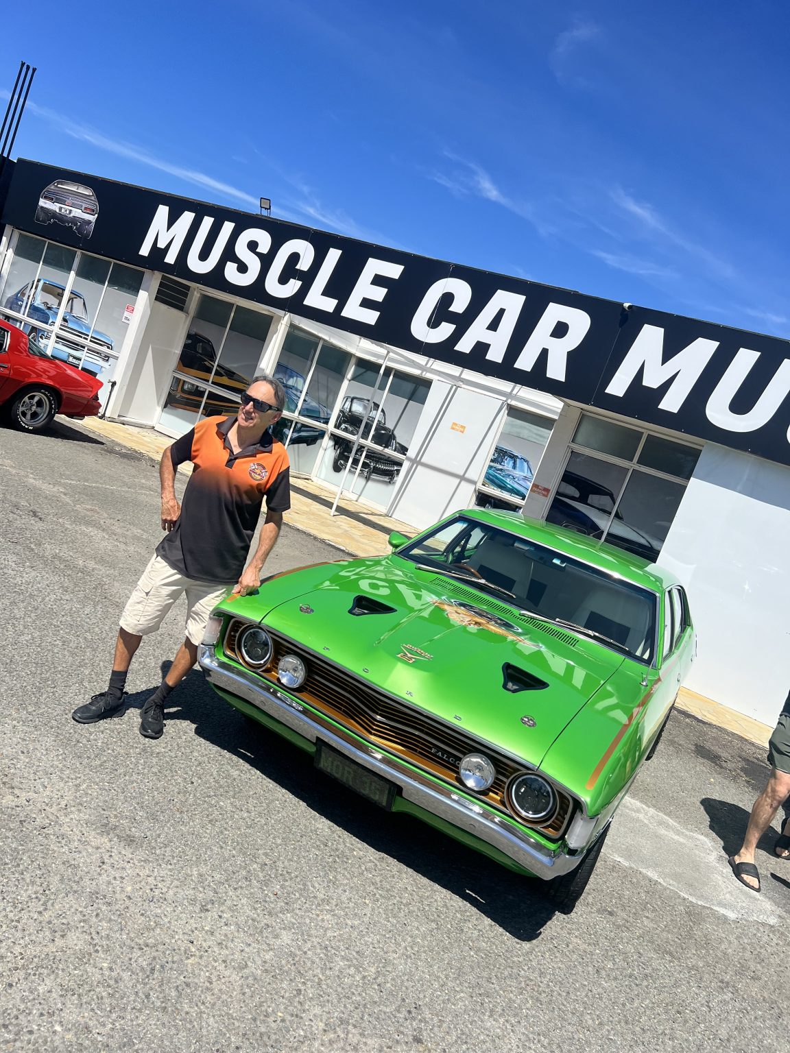 Green Holden Torana in front of the Muscle Car Museum sign