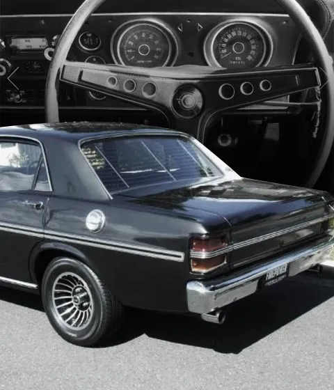 Rear view of a black Ford Falcon XY sedan set against a close-up of its steering wheel and gauges