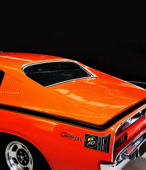 Rear of an orange Chrysler Valiant Charger with black stripe, Charger script and Six Pack Hemi decal
